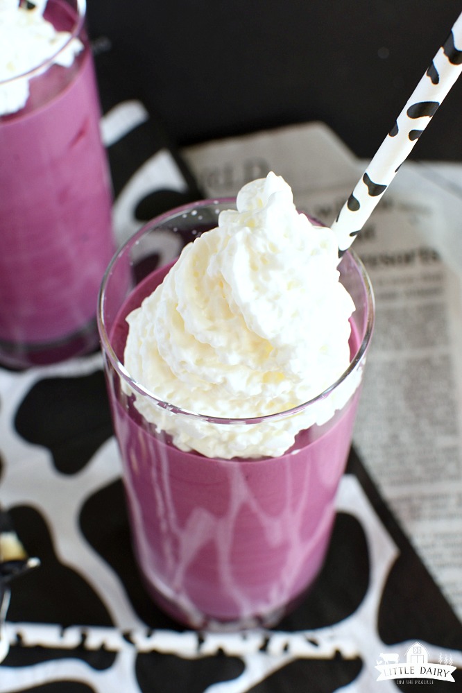 A top view of a purple milkshake with whipped cream on top