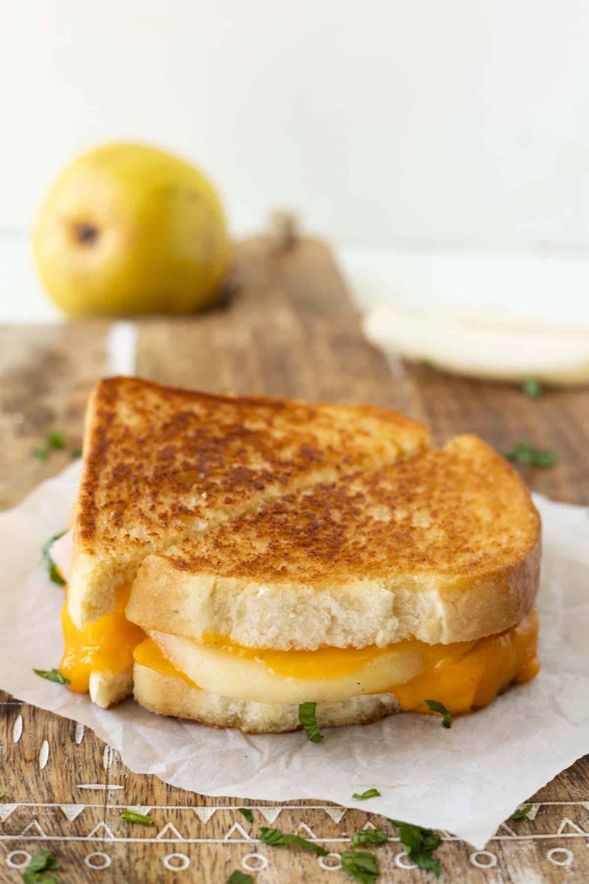 A grilled cheese sandwich made with cheddar cheese and pear slices.