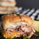 baked ham and cheese slider on a black plate