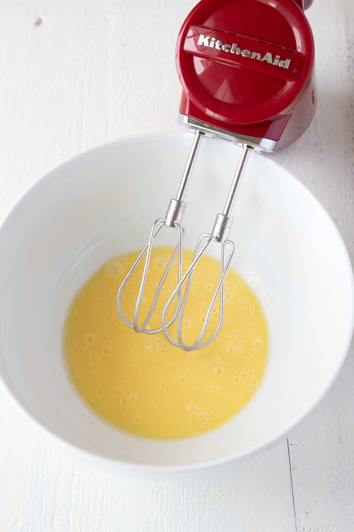 A mixing bowl with melted butter and eggs mixed together.