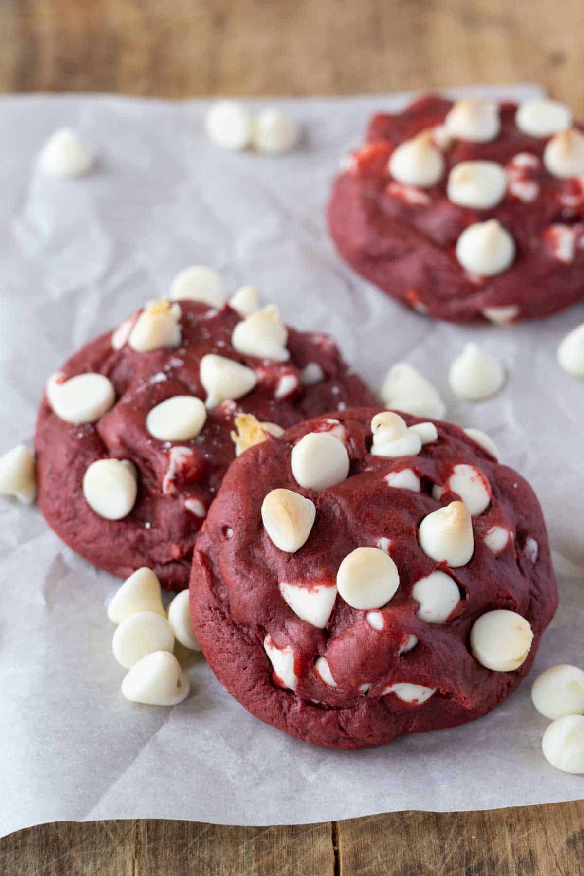 Red velvet cookies from a cake mix with white chocolate chips on a piece of parchment paper. 
