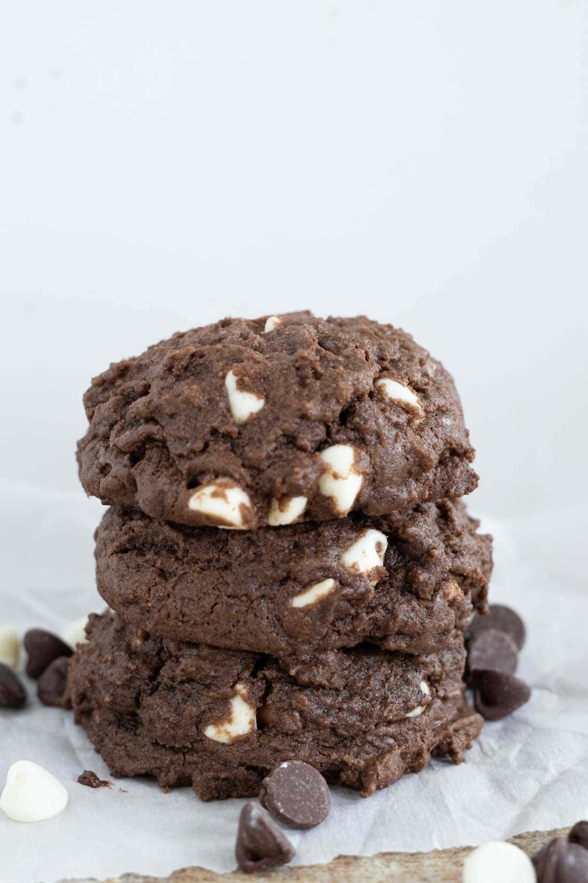 A stack of thick chocolate pudding cookies with white chocolate chips and semi sweet chocolate chips.