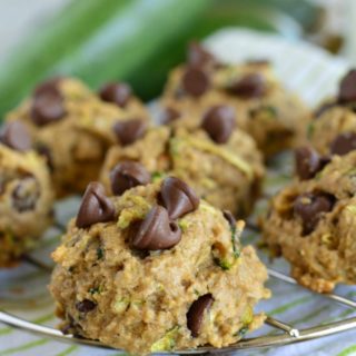 close up shot of chocolate chip zucchini cookies with zucchini in the background