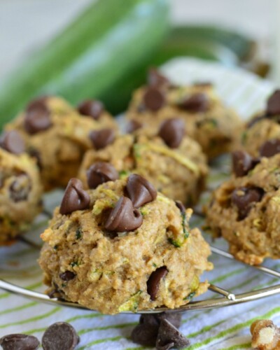 close up shot of chocolate chip zucchini cookies with zucchini in the background