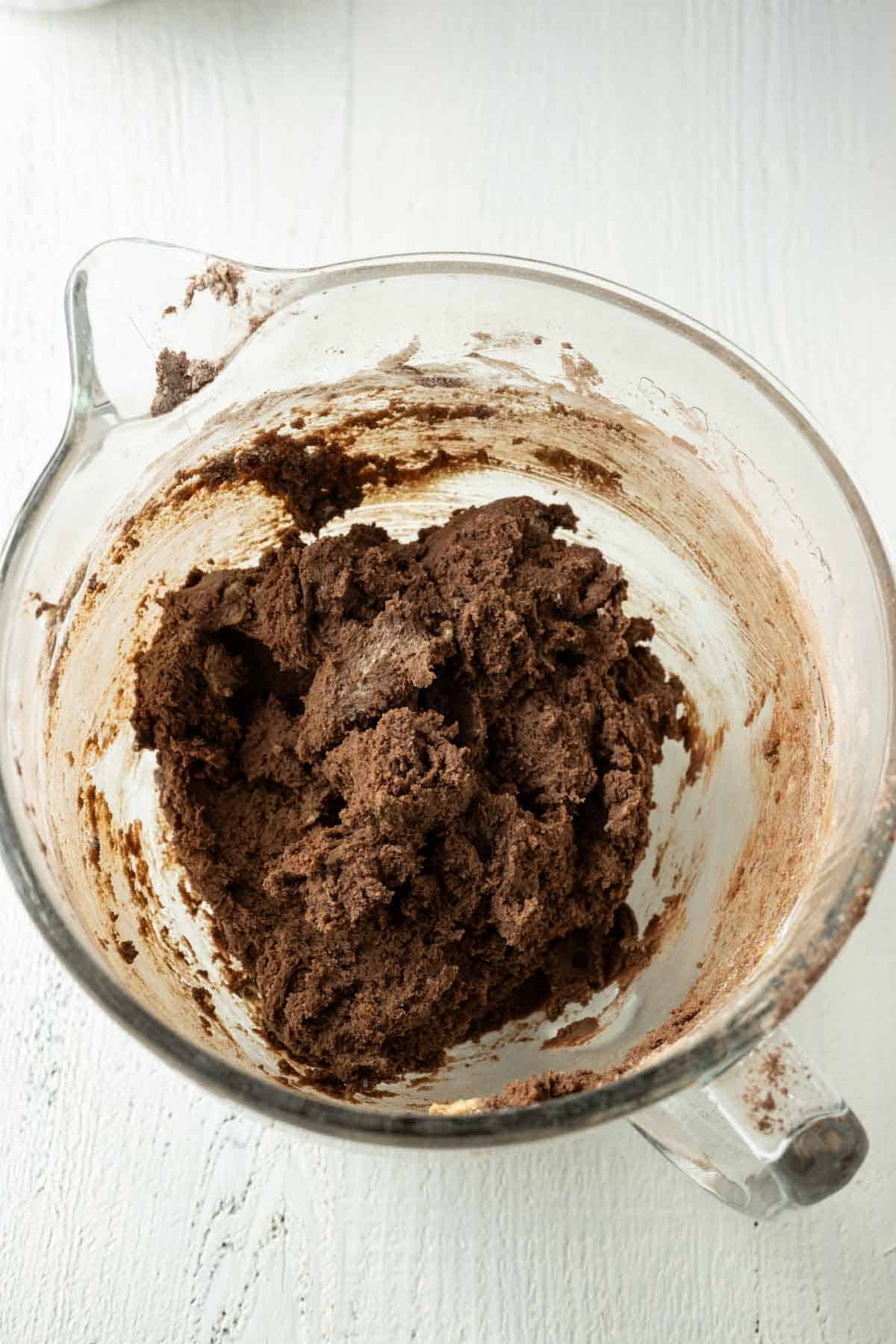 Chocolate cookie dough in a glass mixing bowl.