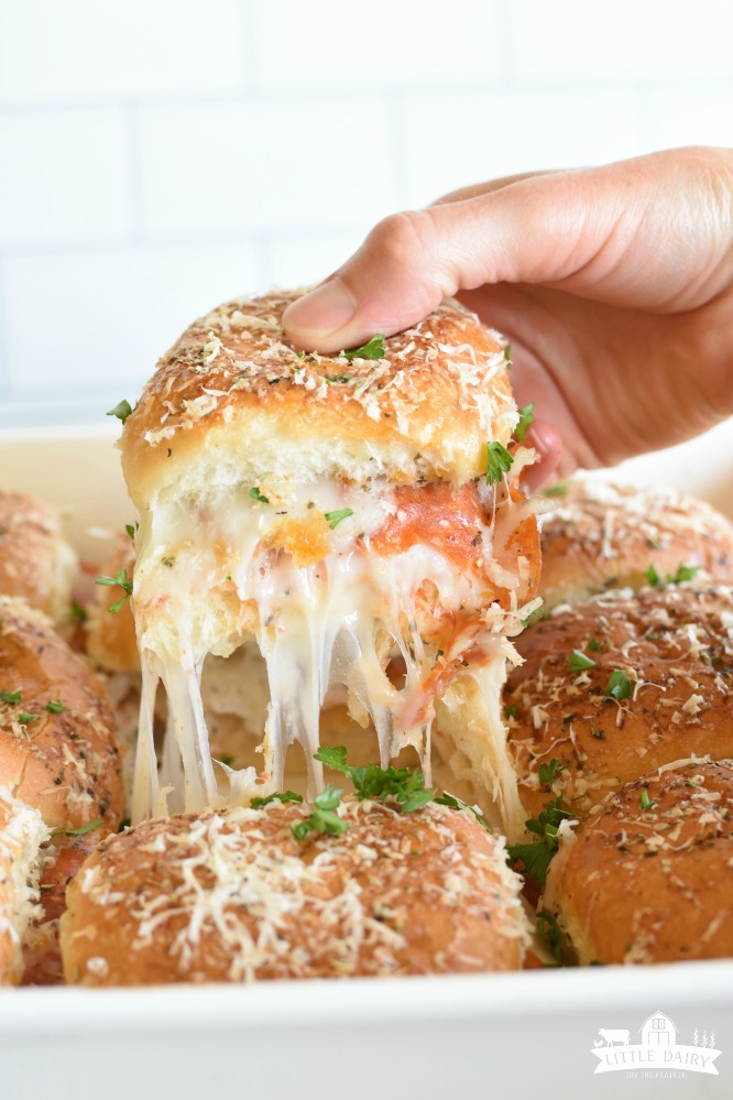 Make Ahead Pepperoni Pizza Sliders are an easy way to make pizza without having to fuss with making crust. They are perfect for packing in lunches. pitchforkfoodie.com #pizza #pepperoni #pepperonipizza #makeaheadmeals #freezereals #lunches #quickmeals #onthegomeals #sandwiches #pizzasandwiches #cheese #schoollunches