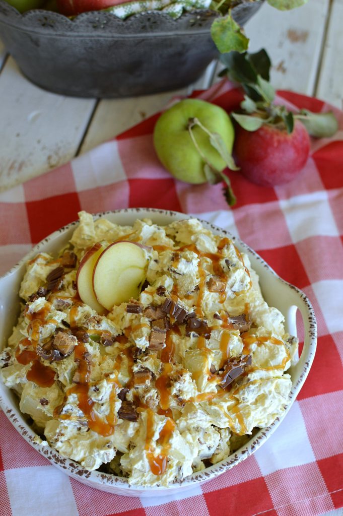 apple salad in a white dish drizzled with caramel ice cream topping