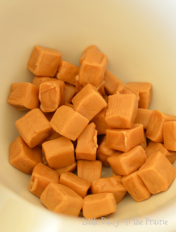 Unwrapped caramel squares in a bowl.