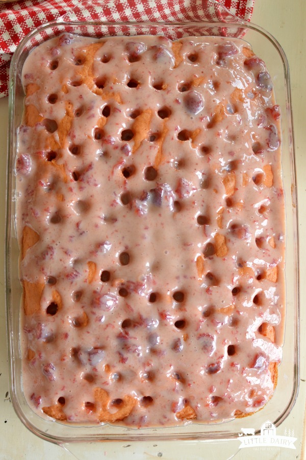 Poke cake with strawberry filling poured on top. 