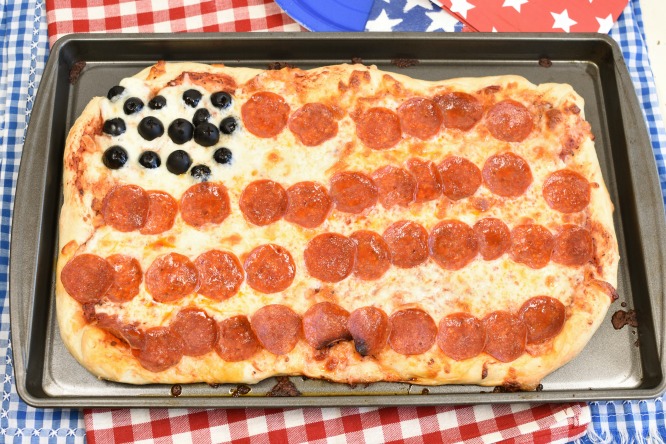 Pepperoni Pizza that looks like an American flag with olives. 