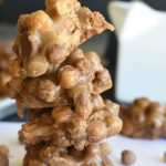 four no bake cereal cookies stacked on top of each other on a white plate.