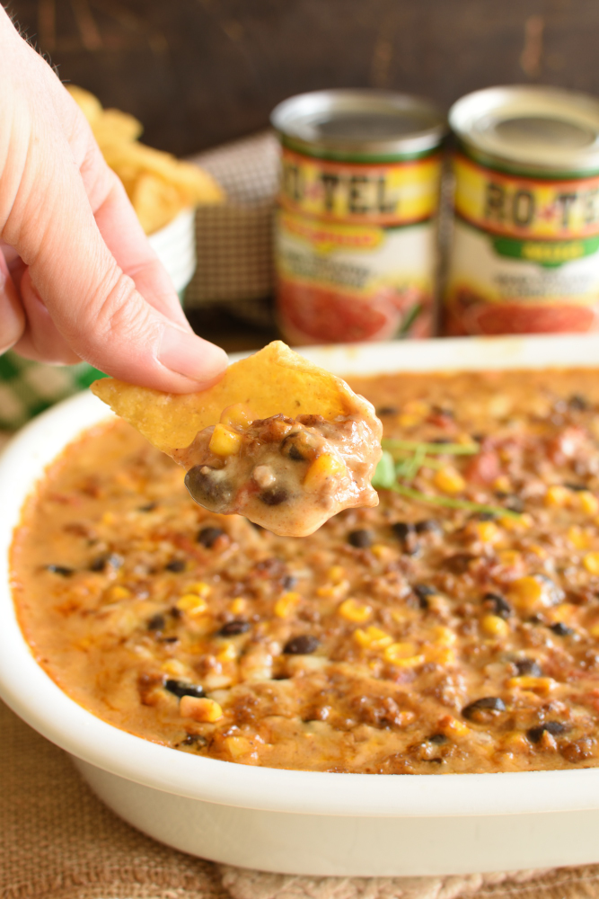 A casserole dish with bean, cheese, and corn dip topped with cilantro.