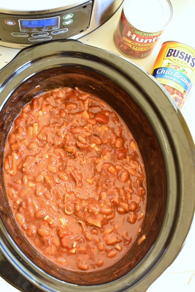 a crock pot with chilli beans in a tomato sauce