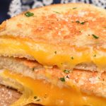 The only thing better than a toasty grilled cheese sandwich filled with gooey melted cheese on the inside, is a Parmesan Crusted Grilled Cheese Sandwich with the most incredible crispy garlic Parmesan crust on the outside! Today I’m beyond excited to share my Parmesan Grilled Cheese Sandwich with you guys! I’ve always been a HUGE lover of grilled cheese sandwiches because who could ever resist ooey gooey cheese nestled between golden brown buttery bread? Not me! Let me tell you though, the crust on my Parmesan Grilled Cheese Sandwich is so stinkin’ divine! It’s so good your going to sink back into your chair, close your eyes and fall in love! Something magical happens when you combine the soft melted cheese on the inside with that crispy, golden brown, buttery and cheesy crust on the outside! Well, by now you know that I married a dairy farmer and have lived on this stinky ol’ farm for almost twenty years! I can’t believe it’s been that long since I agreed to live here with all these cows, flies, crazy hours, and pretty much be joined at the hip with this farm! After I met Justin and he told me he was a dairy farmer I think my heart sunk a little! He was a really great guy but I just didn’t want to be married to a filthy dirty, no days off, muck boot wearing dairyman! Right after I decided my heart didn’t need to be sunken I told him that I’d actually been supporting him for many, many years! I was convinced I was single handedly supporting the entire dairy industry with my love of cheese! I can pound more cheese in a month than most people can pound in a whole year. Surely Justin was getting his a portion of my hard earned money I spend on cheese! I’m seriously an addict. After I’ve been on vacation for a few days I start to really crave salty cheese! I add it to every single meal I make; pasta, scrambled eggs, cheese burgers, salads, mashed potatoes, and even pancakes (don’t knock it till you try it, it’s good)! I’ll take cheese any way I can get it! But I have to admit that ultra comforting Parmesan Crusted Grilled Cheese Sandwiches will always be at the top of my list of favorite meals! It has not one, but two or more kinds of cheese and you can’t beat that! Parmesan Grilled Cheese Sandwiches are still the same old super simple to prepare sandwich you fell in love with as a kid with a fun little twist! Tips for making Parmesan Crusted Grilled Cheese Sandwiches Use soft butter Spread the butter one more time after you add parmesan cheese just to help everything to stick. Grill sandwich over medium heat so the bread doesn’t get browned before the cheese melts. Serve with jam...trust me it’s so flipping tasty! How to customize your Parmesan Crusted Grilled Cheese Sandwich Use a variety of cheeses; Swiss, cheddar, pepper jack, provolone, or a combination. Add meat; deli ham, roast beef; grilled chicken, or bacon Switch up the seasonings used in the Parmesan crust; garlic salt, Salad Supreme, Mrs. Dash’s seasonings Parmesan Crusted Grilled Cheese Sandwiches really are the ultimate comfort food! I pretty much made them twice in the last 12 hours because I happen to think they make a pretty darn good breakfast too! If you want to help me support myself and the rest of the dairy industry whip up a Parmesan Crusted Grilled Cheese Sandwich! Oh, and I’d love to know what’s your favorite kind of cheese to use in grilled cheese sandwiches and what else you pile on it! Leave me a comment and share your ideas!