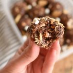 S'mores energy bite - a chocolate ball with marshmallows and crushed graham crackers with a bite taken out of it