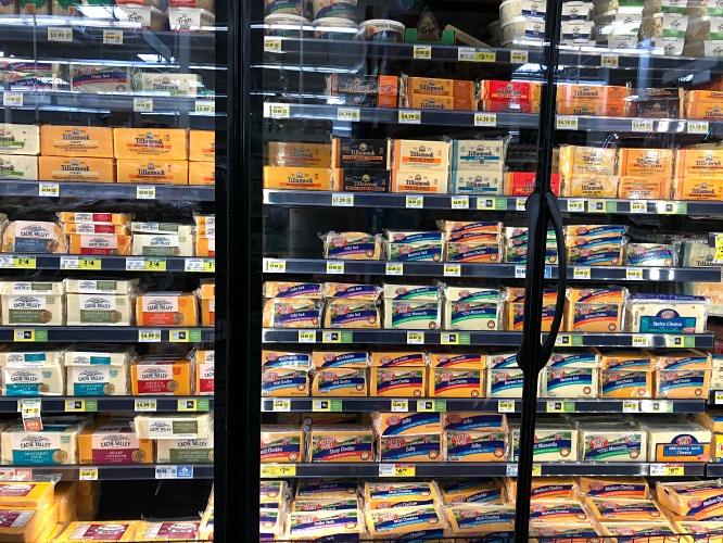 Cheese case at the grocery store with lots of varieties of cheese