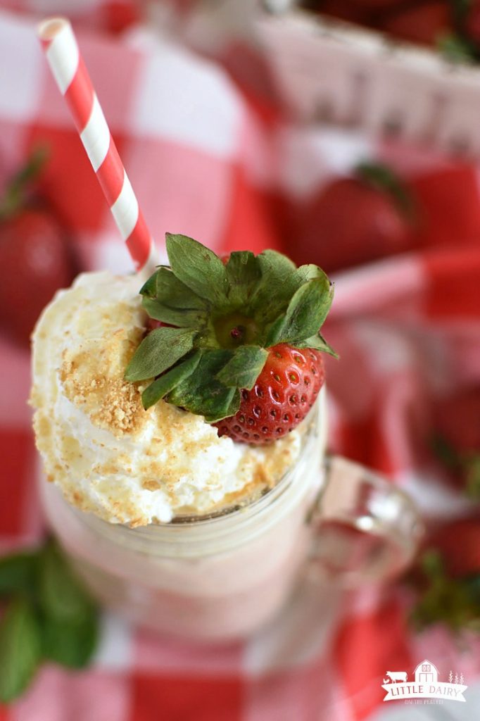 Overhead view of a Strawberry Cheesecake Smoothie with a strawberry and whipped cream