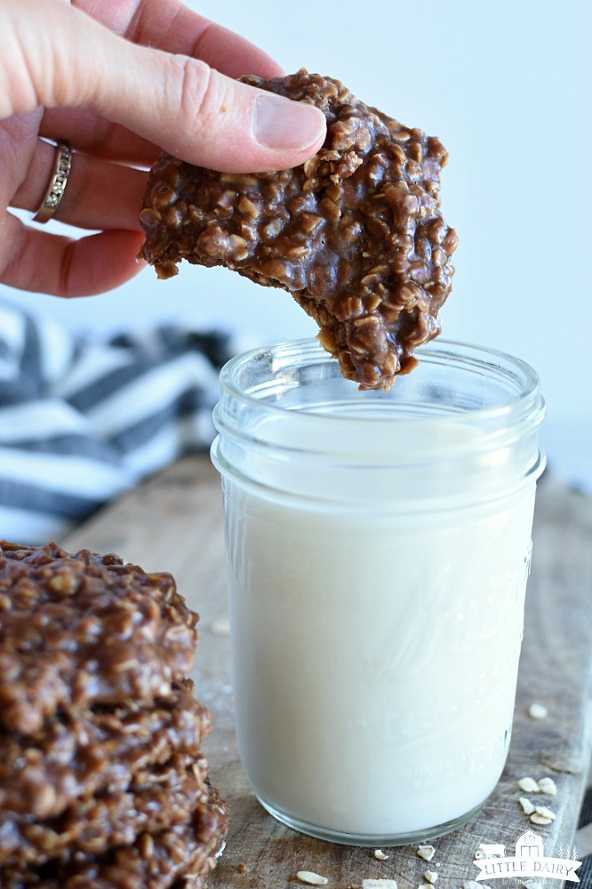 dunking a no bake peanut butter cookies in a jar of milk