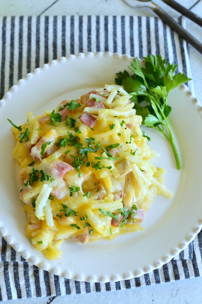 birds eye view of a square of baked breakfast casserole made with hasbrowns and diced ham