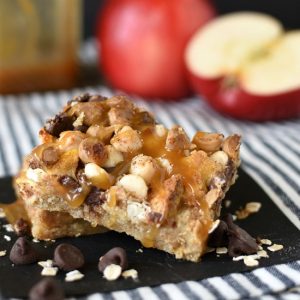 Caramel Apple Crisp Magic Cookie Bars have an oat crust, and are topped with apples, chocolate, coconut, and drizzled with sweetened condensed milk! pitchforkfoodie.com #cookies #barcookies #dessert #desserts #dessertbars #magiccookies #magicbars #apples #caramelapples #applecrisp #appledesserts #fivelayercookies #easyrecipe #recipe #sweettooth