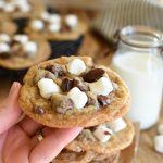 A hand holding a baked s'mores cookie