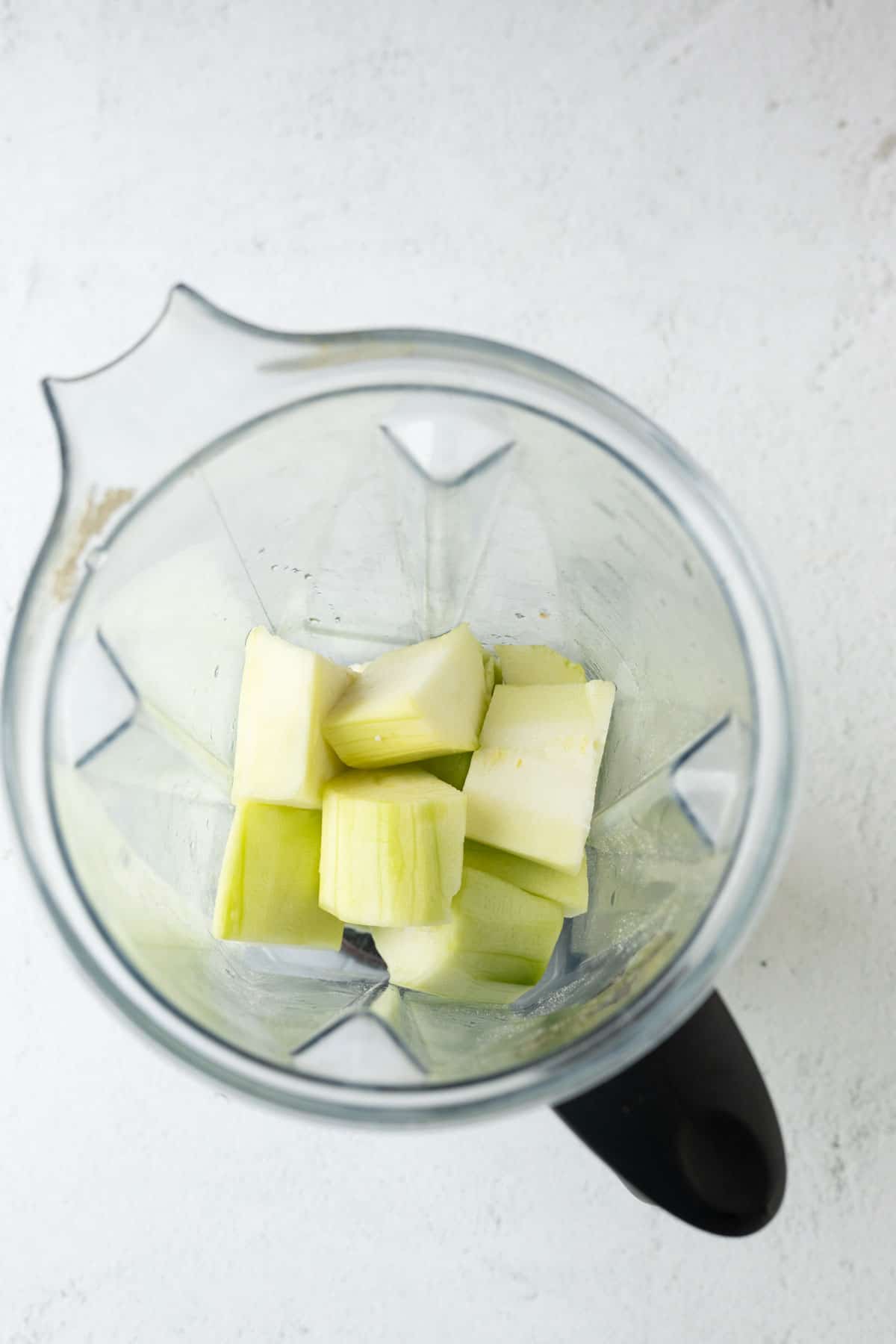 Peeled zucchini cut into chunks in a blender.