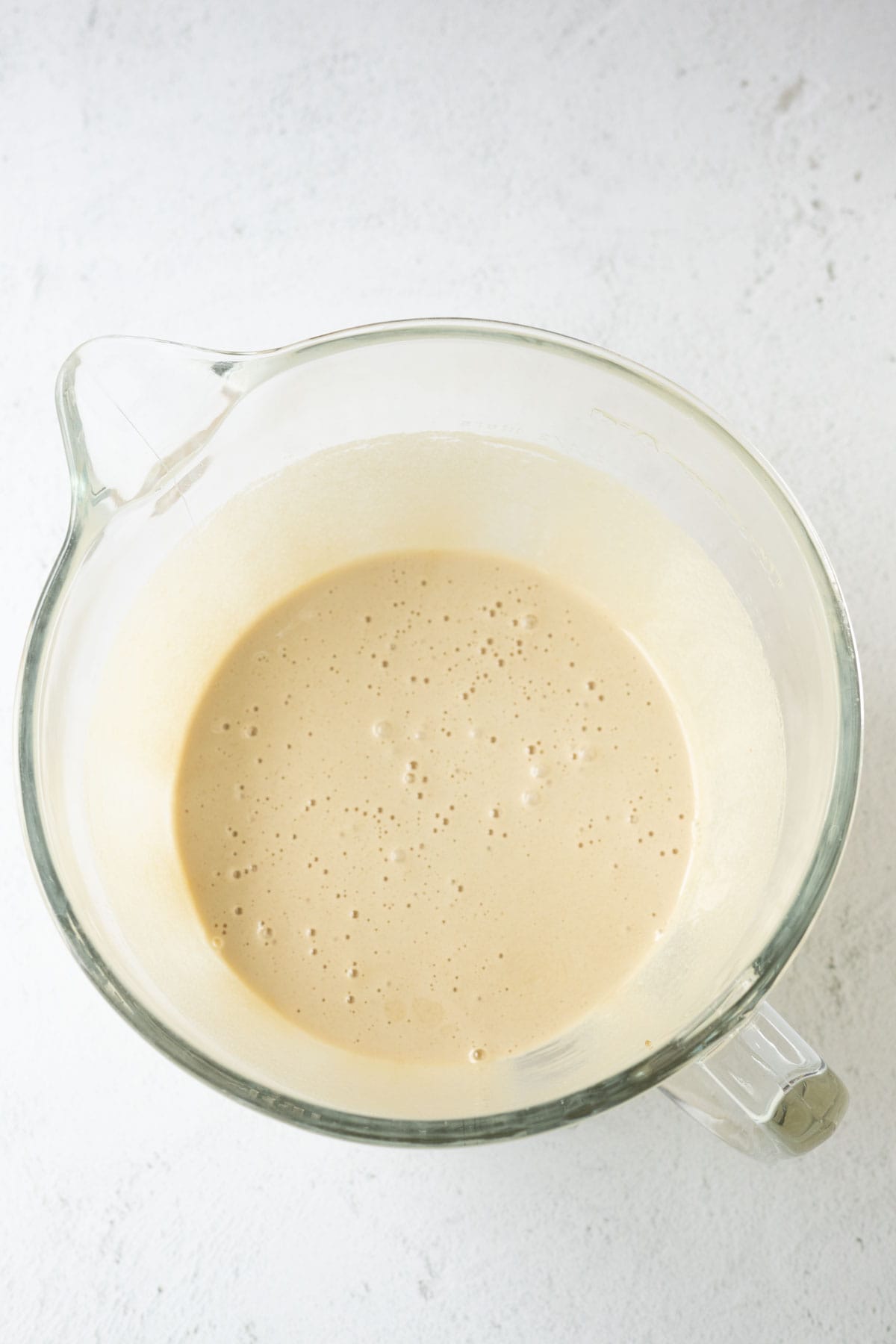 Beaten eggs, white sugar, and brown sugar in a glass mixing bowl.