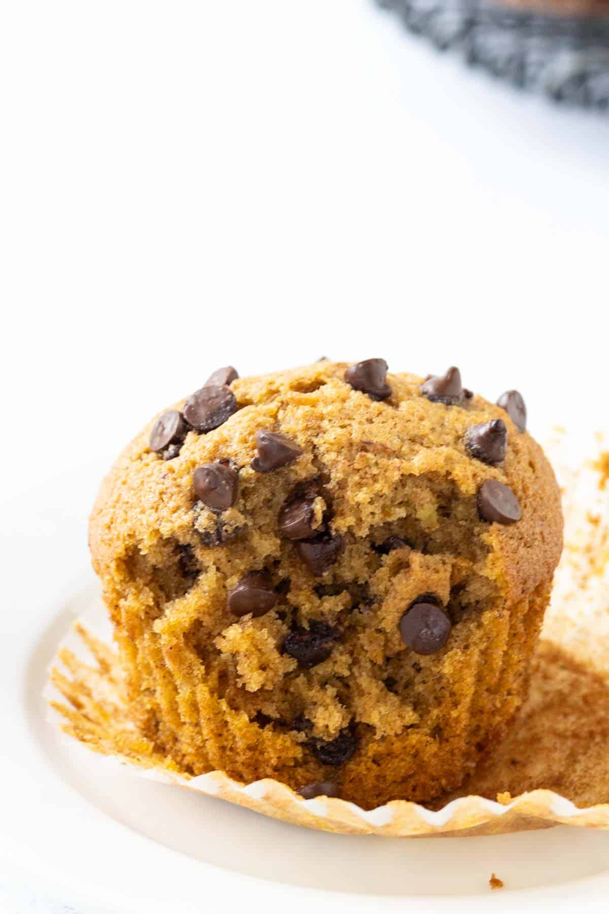 Pumpkin zucchini muffins with a bite taken out of it.
