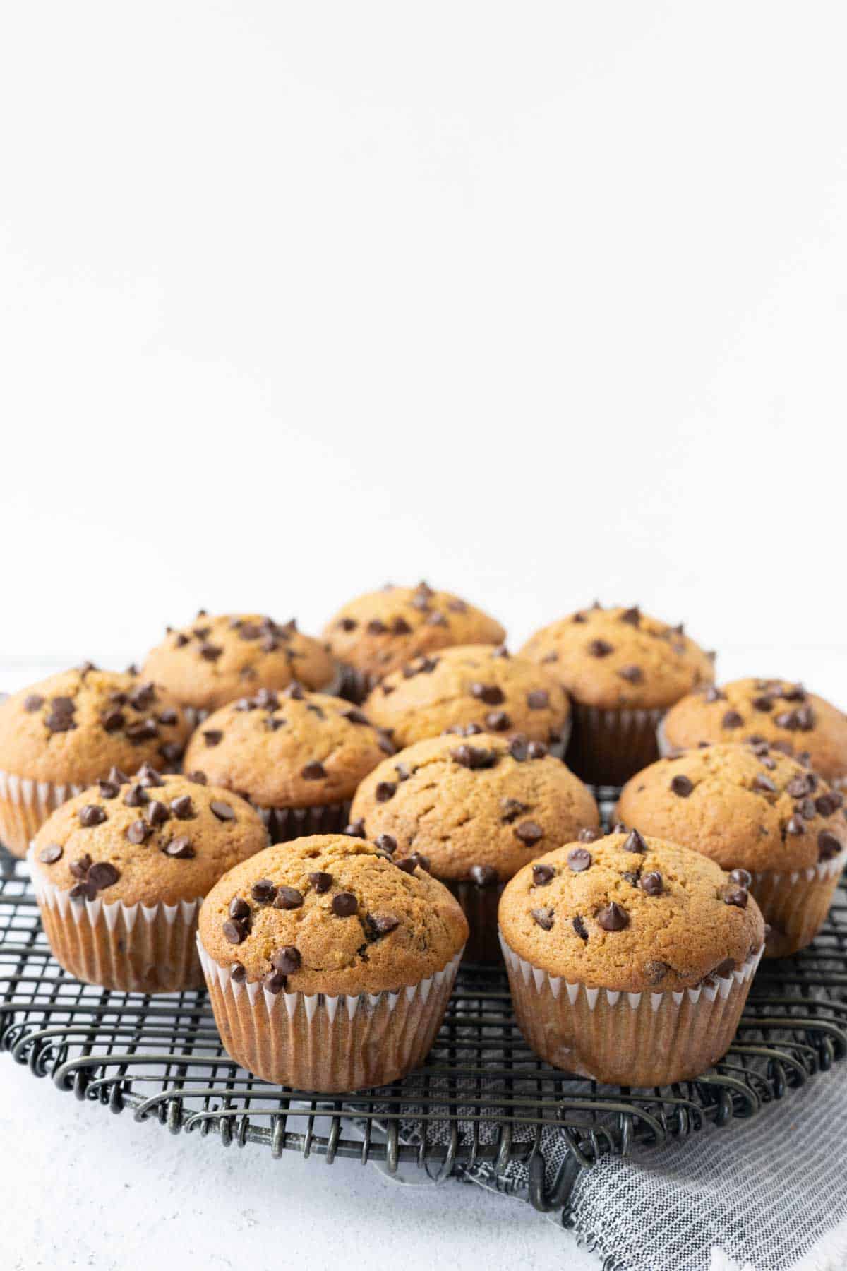 Pumpkin zucchini muffins on a wire cooling rack.