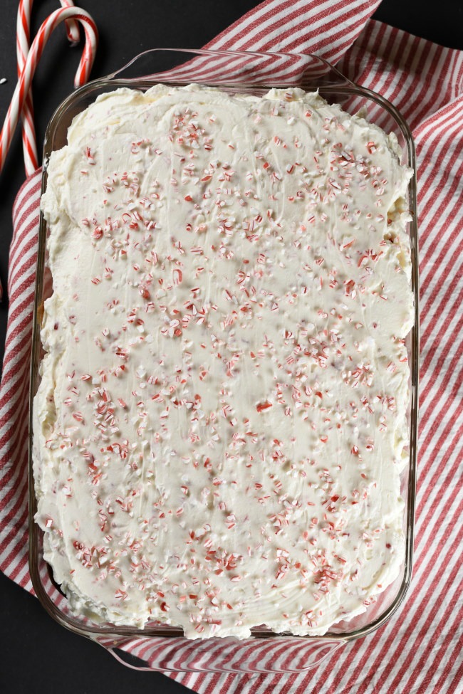 birds eye view of baked cake with whipped cream frosting and sprinkled with crushed candy canes