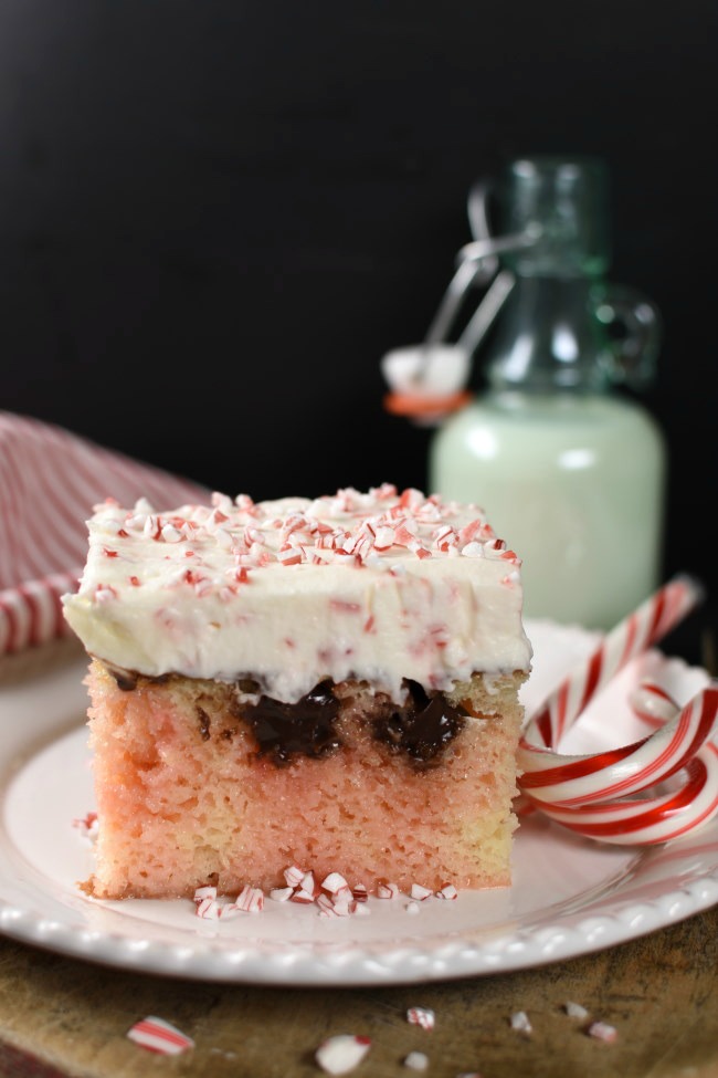 Piece of white poke cake with pink marbeling, chocolate, and cheescake topping