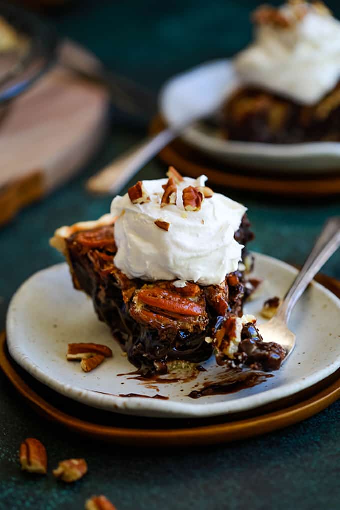 A slice of brownie pecan pie with whipped cream