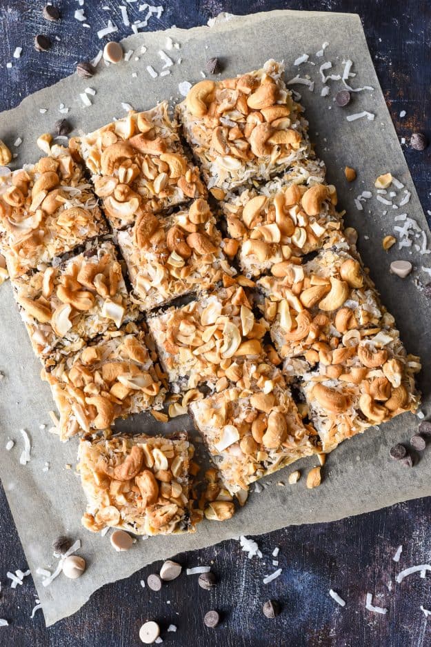 a batch of magic bar squares with coconut and cashews on a paper