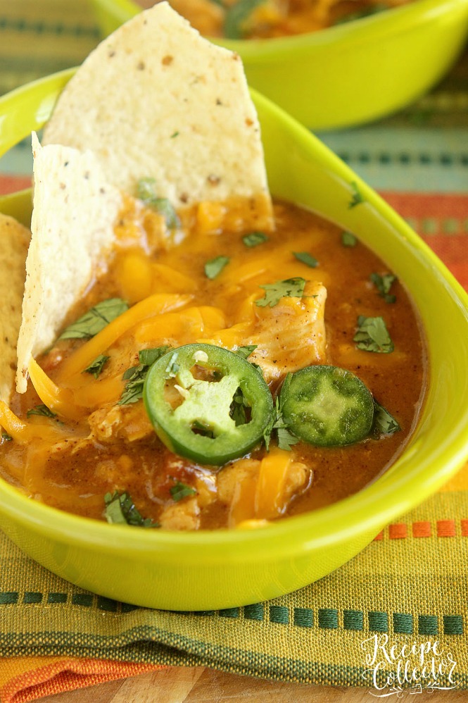 a bowl of soup with melted cheese and sliced jalapeno