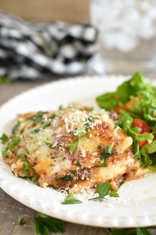 baked ravioli casserole on a plate with green salad