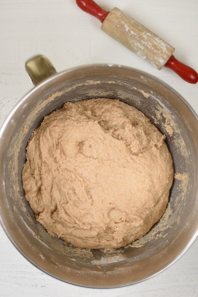 a silver mixing bowl with whole wheat bread dough