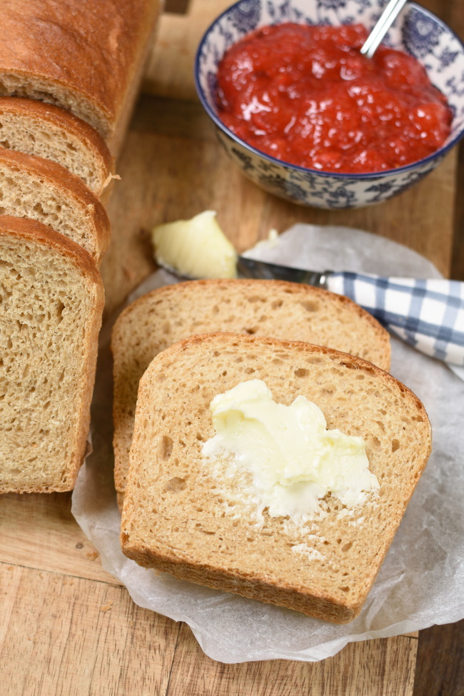 buttered whole wheat bread with a dish of strawberry jam