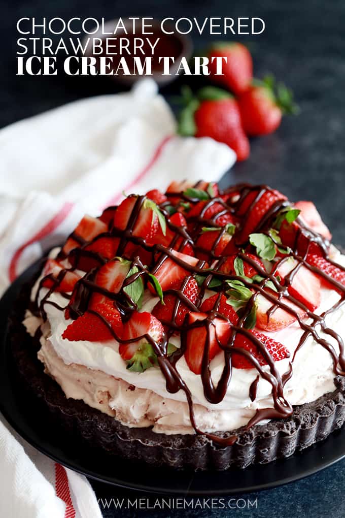 a chocolate crust tart topped with ice cream, sliced strawberries, and a drizzle of chocolate sauce