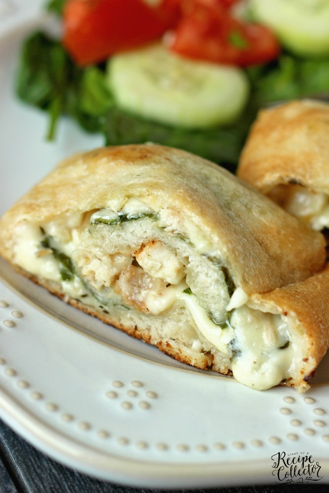 a calzone stuffed with chicken and spinach on a plate with a green salad