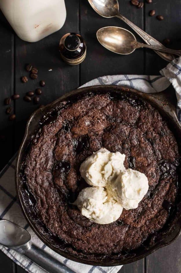 a top view of chocolate cake in a cast iron skillet topped with scoops of icecream