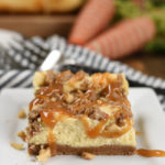 a square of cheesecake on with carrot cake stressel and chopped walnuts