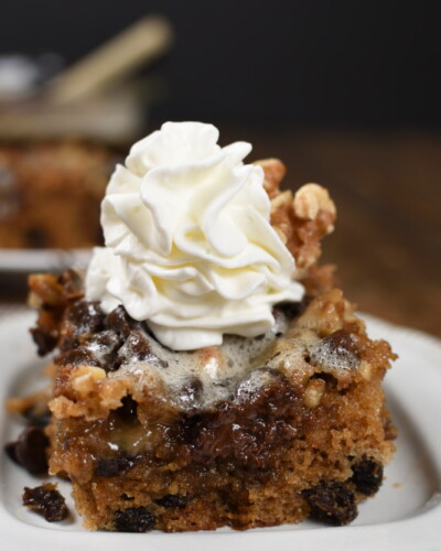 a square of chocolate chip cake topped with whipped cream