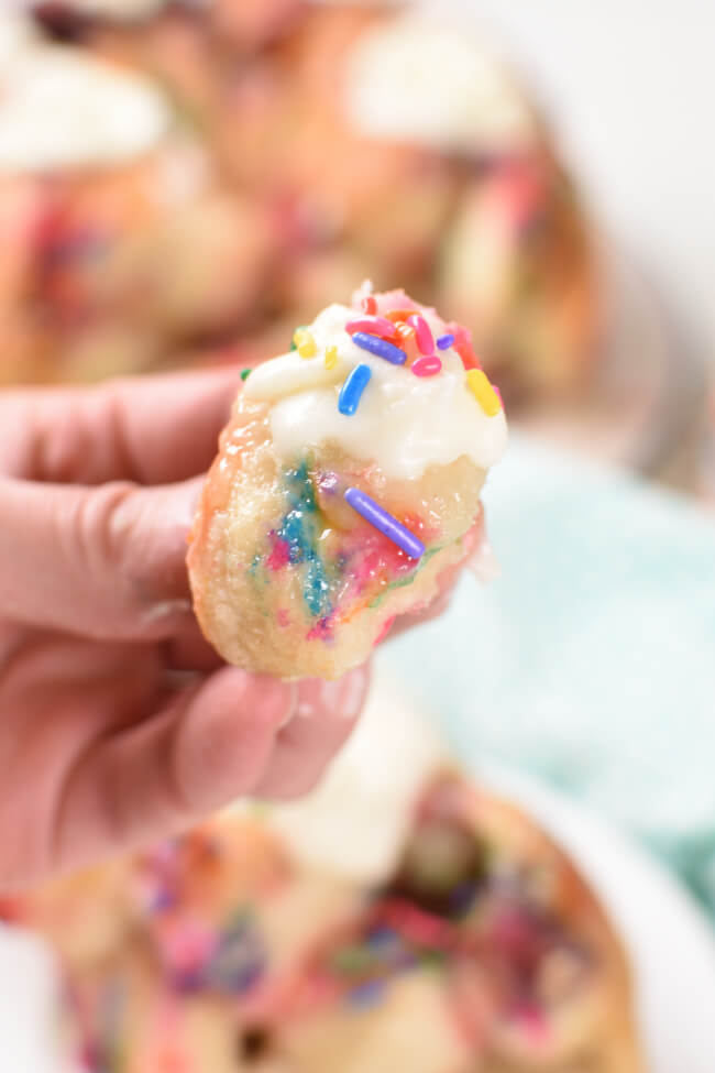 a bite of monkey bread with icing and sprinkles on top