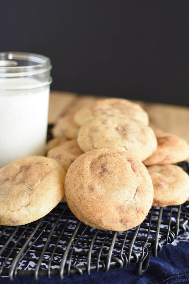 baked cookies on a cooling rack with a small jar of milk
