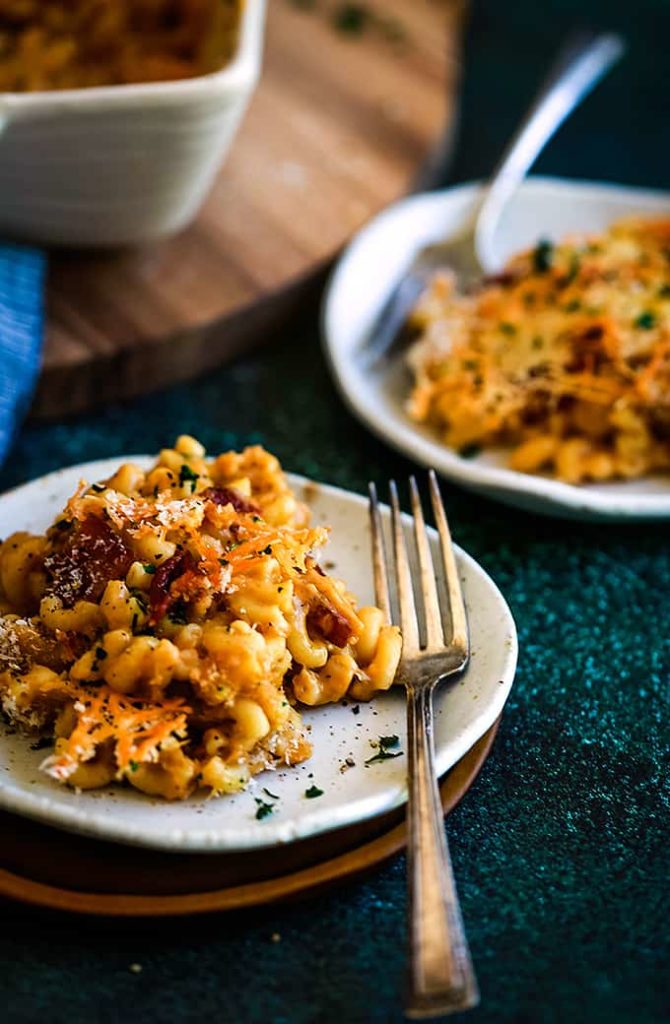 two plates with macaroni and cheese with bacon chunks