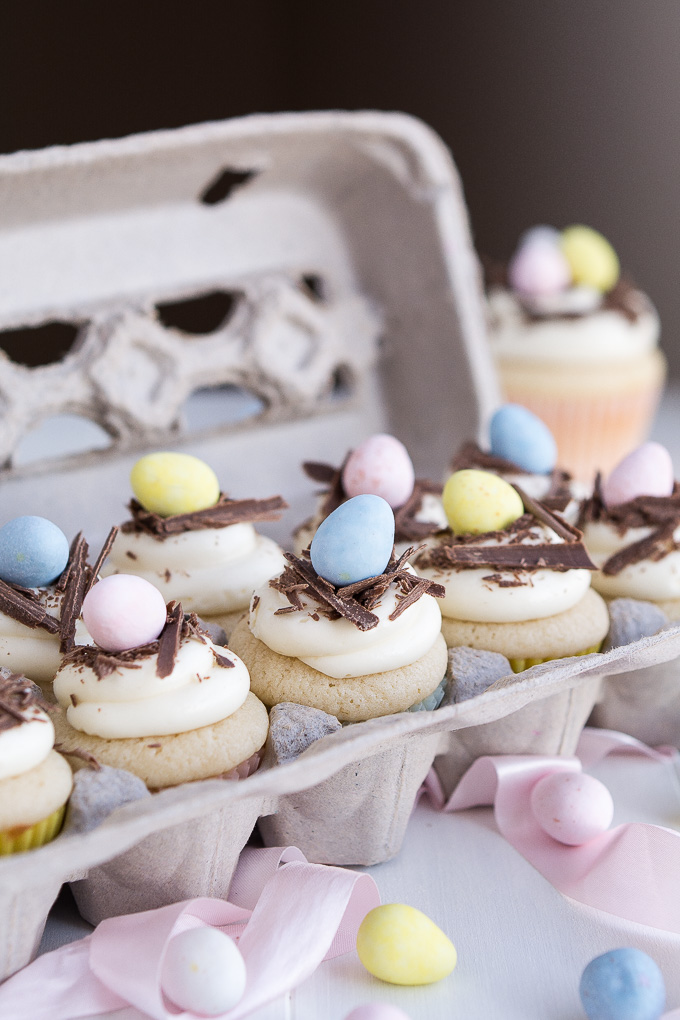 an egg carton with vanilla cupcakes decorated with chocolate eggs