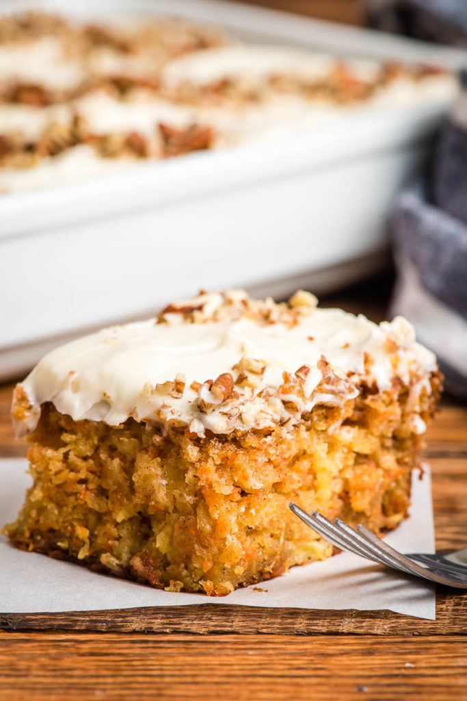 a square of carrot cake with cream cheese icing and chopped walnuts