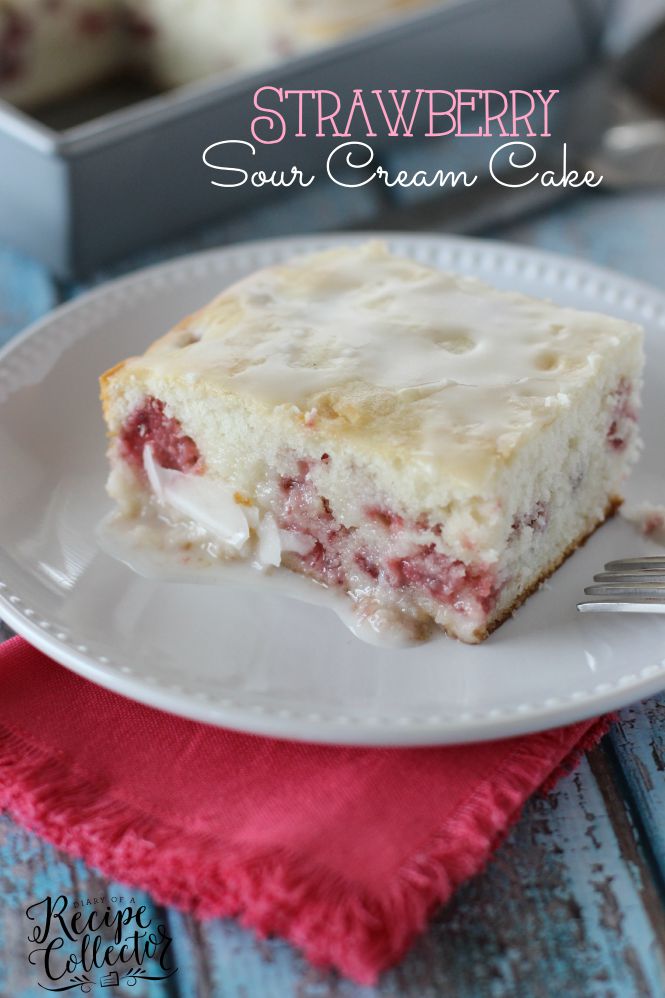 a square of white cake filled with strawberries and topped with white glaze