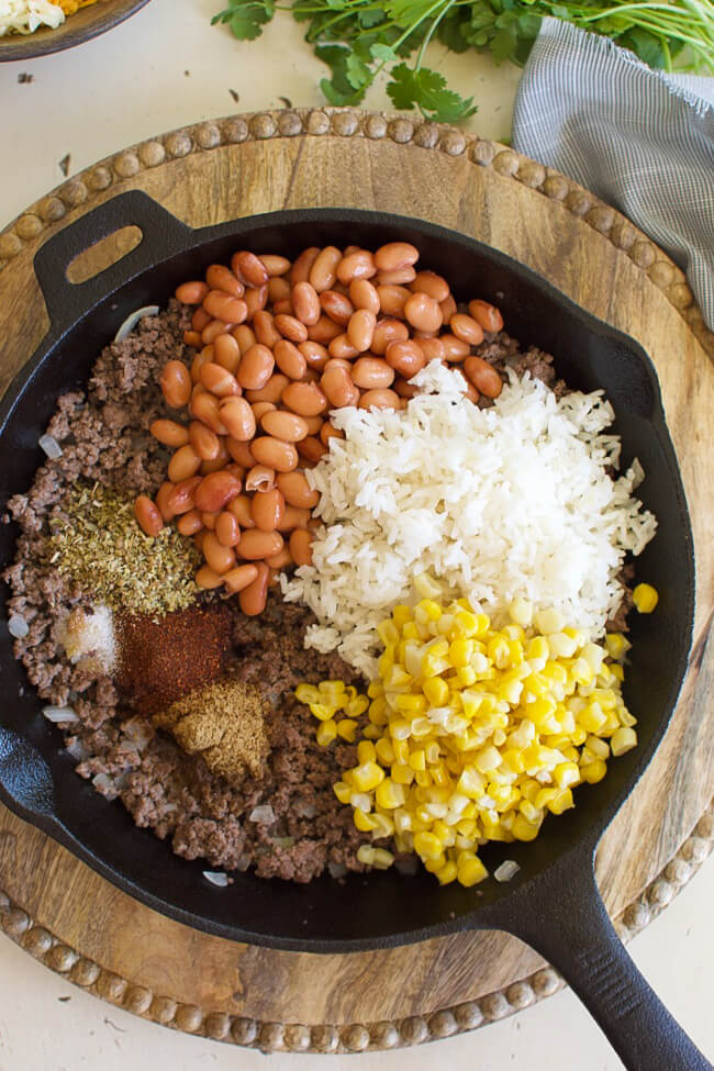 beans, corn, rice, and seasonings over ground beef in a skillet
