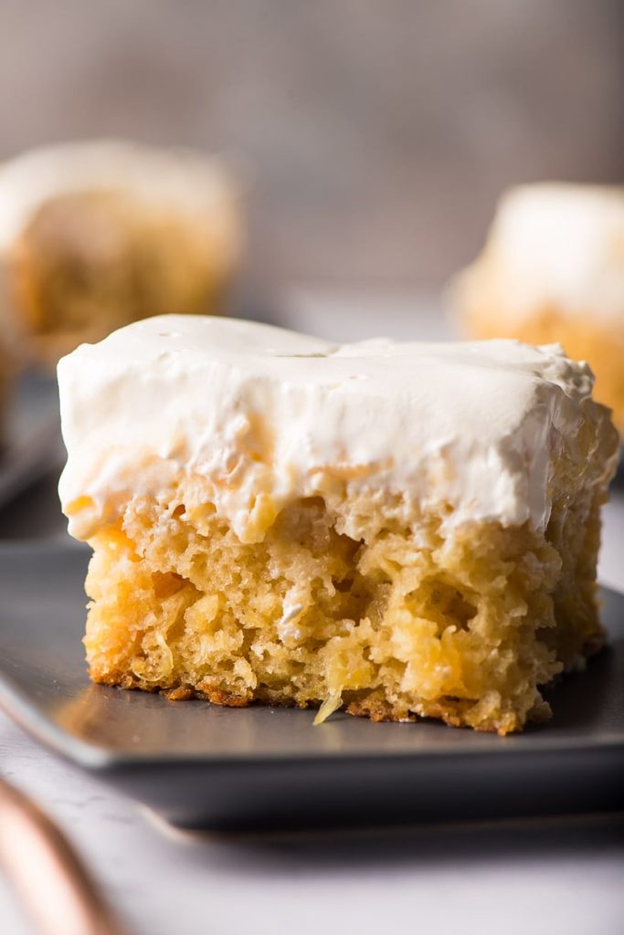 a piece of pineapple cake with whipped topping